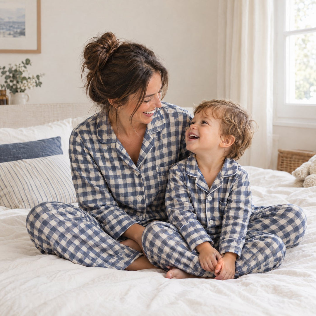 Maman et son enfant en pyjamas à carreaux assortis assis sur un lit